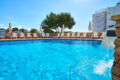 a swimming pool with a fountain in a hotel at Apartamentos Azul Playa in Cala d´Or
