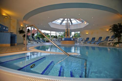 a swimming pool in a hotel with a slide in it at Parkhotel Flora am Schluchsee in Schluchsee