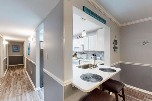 a kitchen with a sink and a counter with two chairs at Colony Club E1 in Gulf Shores