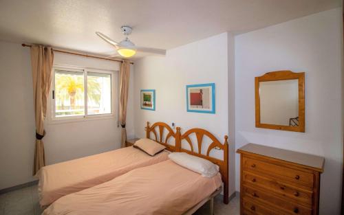 a bedroom with a bed and a mirror and a dresser at Las Terrazas - Apartamento en segunda línea Playa Cargador ALBERT VILLAS in Alcossebre