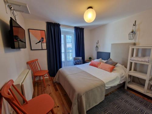 een slaapkamer met een bed, een stoel en een raam bij Apartamentos Alfama Fado in Lissabon