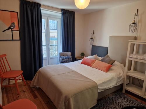 een slaapkamer met een bed en een raam bij Apartamentos Alfama Fado in Lissabon