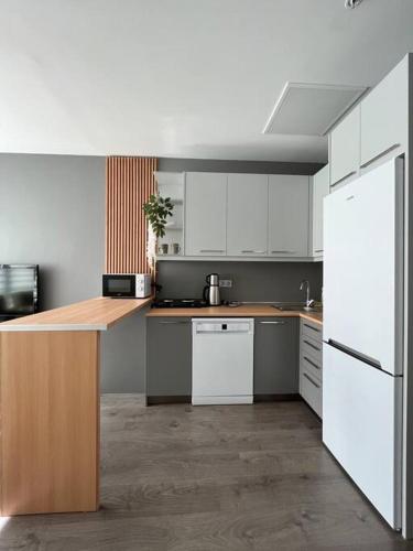 a kitchen with white cabinets and a wooden counter top at Ataşehir in Istanbul