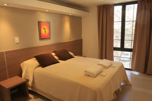 a bedroom with a bed with two towels on it at HOTEL CONTINENTAL PLAZA in Villa Carlos Paz