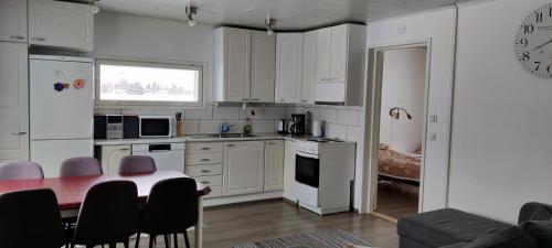 uma cozinha com mesa e cadeiras num quarto em Koskela em Kalajoki