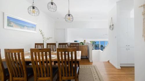 a dining room with a table and chairs at Dutchie's Sand & Sea Beach House - easy walk to the beach in Nelson Bay