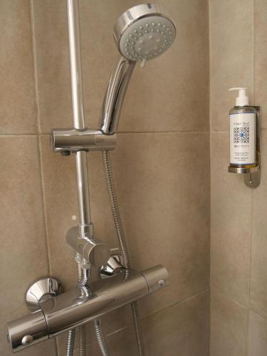 une douche avec pommeau de douche dans une salle de bain dans l'établissement Hôtel De L'Amphithéâtre, à Nîmes