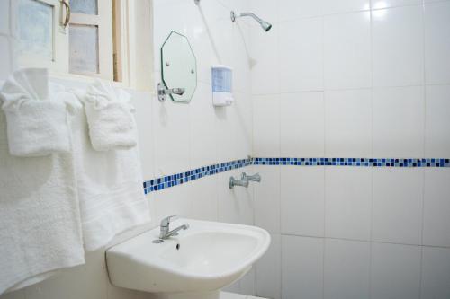 y baño blanco con lavabo y ducha. en Sinopia Inn, en Port Antonio