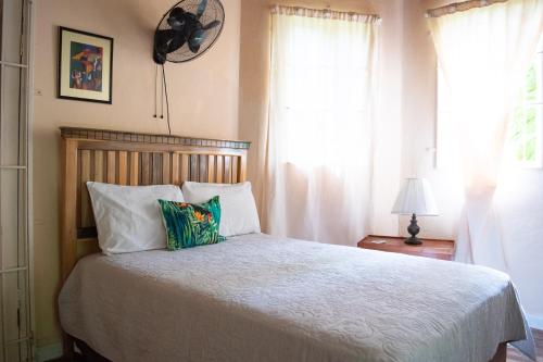 a bedroom with a large bed with two pillows at Sinopia Inn in Port Antonio