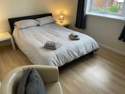 um quarto com uma cama com uma cadeira e um sofá em 3-Bed House in Stoke-on-Trent Free Sky Free Wifi em Stoke-on-Trent