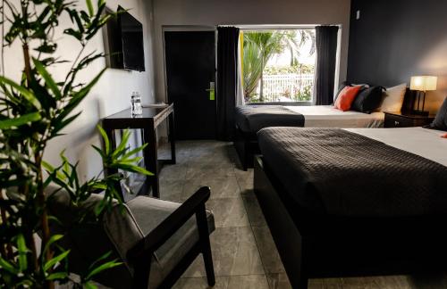 a hotel room with two beds and a plant at Up Midtown in Miami
