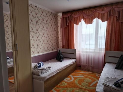 - une petite chambre avec un lit et une fenêtre dans l'établissement Апартаменты в Хромтау. Энглер, à Khromtaū