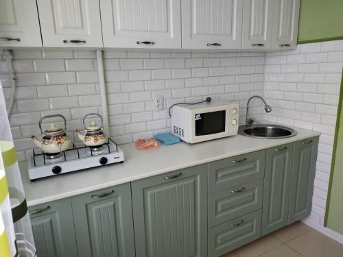 - un comptoir de cuisine avec un four micro-ondes et un évier dans l'établissement Апартаменты в Хромтау. Энглер, à Khromtaū