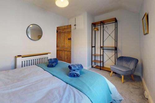 - une chambre avec un lit, une chaise et un miroir dans l'établissement Gull Cottage, à Conwy