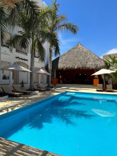 uma piscina em frente a um hotel com palmeiras em Hotel Estrella de Mar em Zipolite
