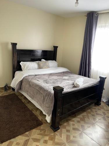 1 dormitorio con 1 cama grande y ventana grande en Inviting 3-Bed Apartment in Nairobi en Nairobi