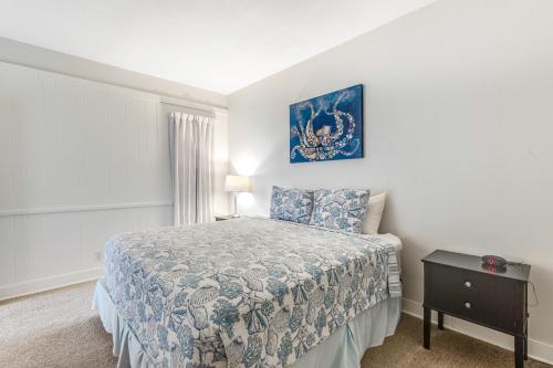 a small bedroom with a bed and a night stand at Gulls Nest (610) in Seaside