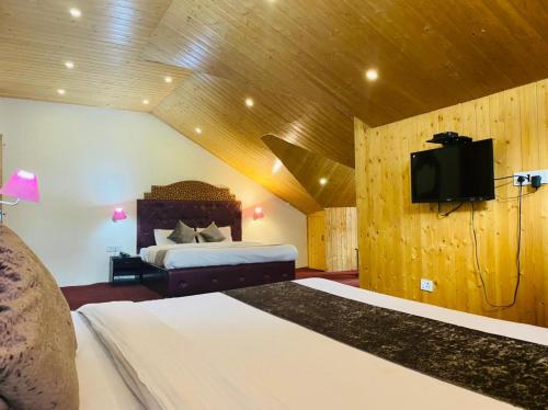 1 dormitorio con 1 cama y TV de pantalla plana en Hotel Hadimba palace en Manāli