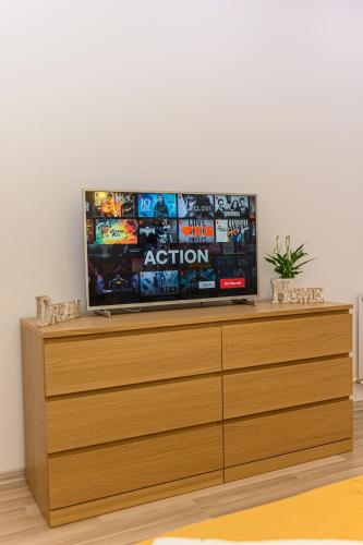 a flat screen tv on top of a wooden dresser at JAD - Comfortable -3 Rooms & 2 Rooms Apartments in Braşov