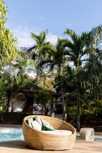 a wooden boat sitting next to a pool with palm trees at SoulShine in Playa Avellana