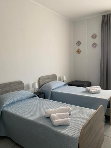 Habitación con 3 camas y toallas. en Il Girasole, en Catania