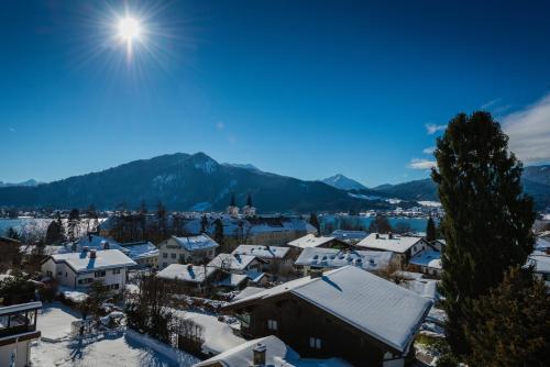 a city covered in snow with mountains in the background at Aparthotel Fackler in Tegernsee