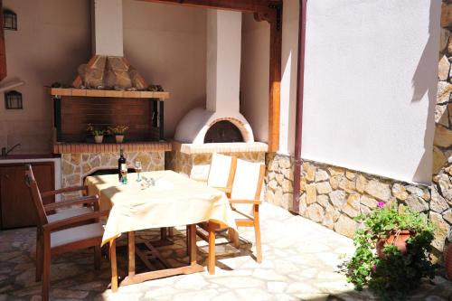 una mesa y sillas en un patio con horno de pizza en Pansion Evi, en Ammoulianí