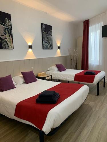 - deux lits dans une chambre d'hôtel rouge et blanche dans l'établissement Hôtel Restaurant de l'Union, à Mirambeau