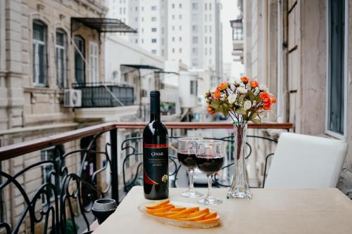 City Inn Nizami Boutique Hotel في باكو: زجاجة من النبيذ وأكواب على طاولة على شرفة