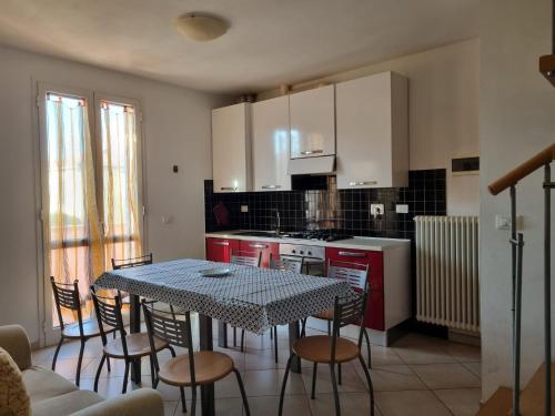 a kitchen with a table and chairs and a kitchen with white cabinets at Giacomo Home in Marina di Cecina