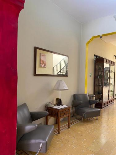 a living room with chairs and a table and a mirror at Hotel Doña Chela En Calvillo in Calvillo