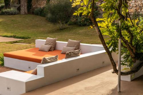 a white couch with pillows sitting in a garden at Dimora Dei Semplici in Ostuni