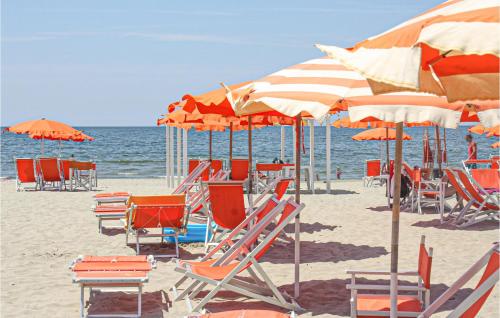 a bunch of chairs and umbrellas on a beach at Lovely Home In Massarosa With Wifi in Massarosa