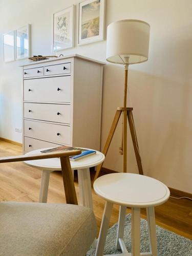 a living room with a table and a lamp and a chair at VINESTIA cityloft Storchenblick Leibnitz in Leibnitz