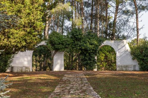a garden with two arches in the middle of a yard at Dimora Dei Semplici in Ostuni