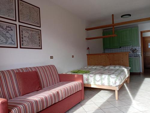 a living room with a couch and a bed at THE LITTLE NEST in Valdisotto