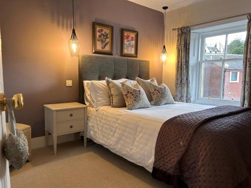 sypialnia z dużym łóżkiem i oknem w obiekcie The Cottage w mieście Dunblane