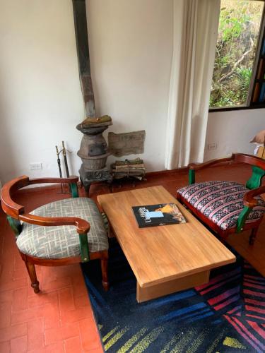 a living room with a table and chairs and a stove at Hotel Rokas de Suesca in Suesca