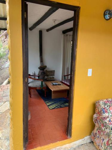 a doorway into a room with a table and a yellow wall at Hotel Rokas de Suesca in Suesca