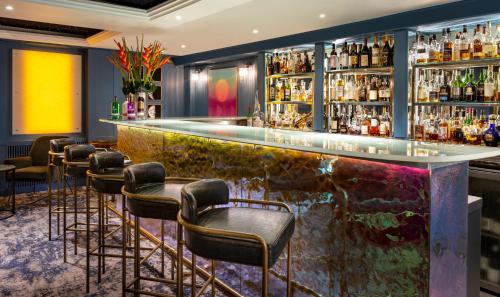 um bar num hotel com bancos de bar em The Capital Hotel, Apartments & Townhouse em Londres