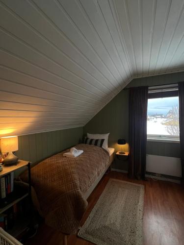 a bedroom with a bed with a large window at Drømmefabrikken in Bleik