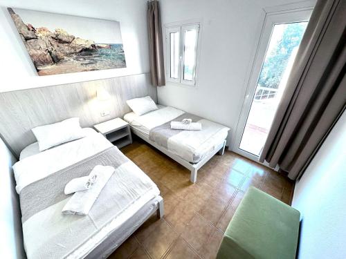 a small room with two beds and a couch at VILLA BLANCA in Cala Ferrera