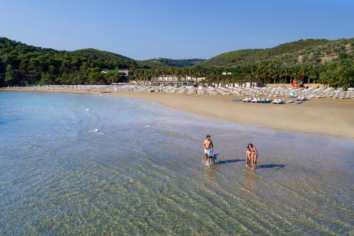 zwei Menschen laufen im Wasser am Strand in der Unterkunft Gattarella Family Resort - Standard Half-Board à buffet in Vieste