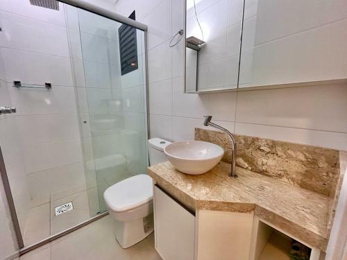 a bathroom with a sink and a toilet and a shower at Ap 2 dormitórios com piscina a 4 quadras do mar Le Monde in Capão da Canoa