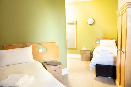 a bedroom with two beds and a mirror at Kents Hill Park Training & Conference Centre in Milton Keynes