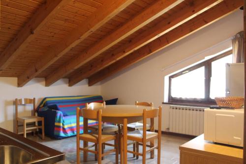 una cucina con un tavolo e sedie in una stanza di Casa Pineta a Ledro