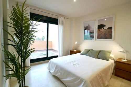 1 dormitorio con cama blanca y ventana grande en El Balcón del Novo -Novo Sancti Petri- Luxury 3 Bedrooms - Piscina y Pista Padel, en Chiclana de la Frontera