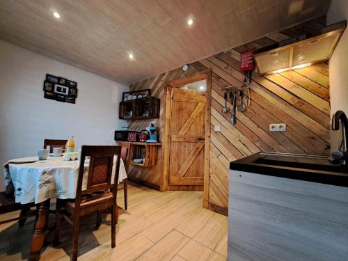 a kitchen with a table and a wooden wall at La Ptit Marie in Houffalize