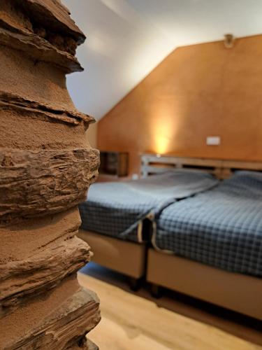 a bedroom with two beds and a stone wall at La Ptit Marie in Houffalize