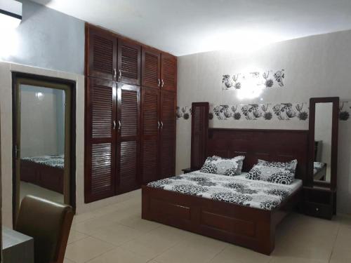 a bedroom with a bed and a mirror in it at Hôtel Résidence Georges Colette in Yopougon